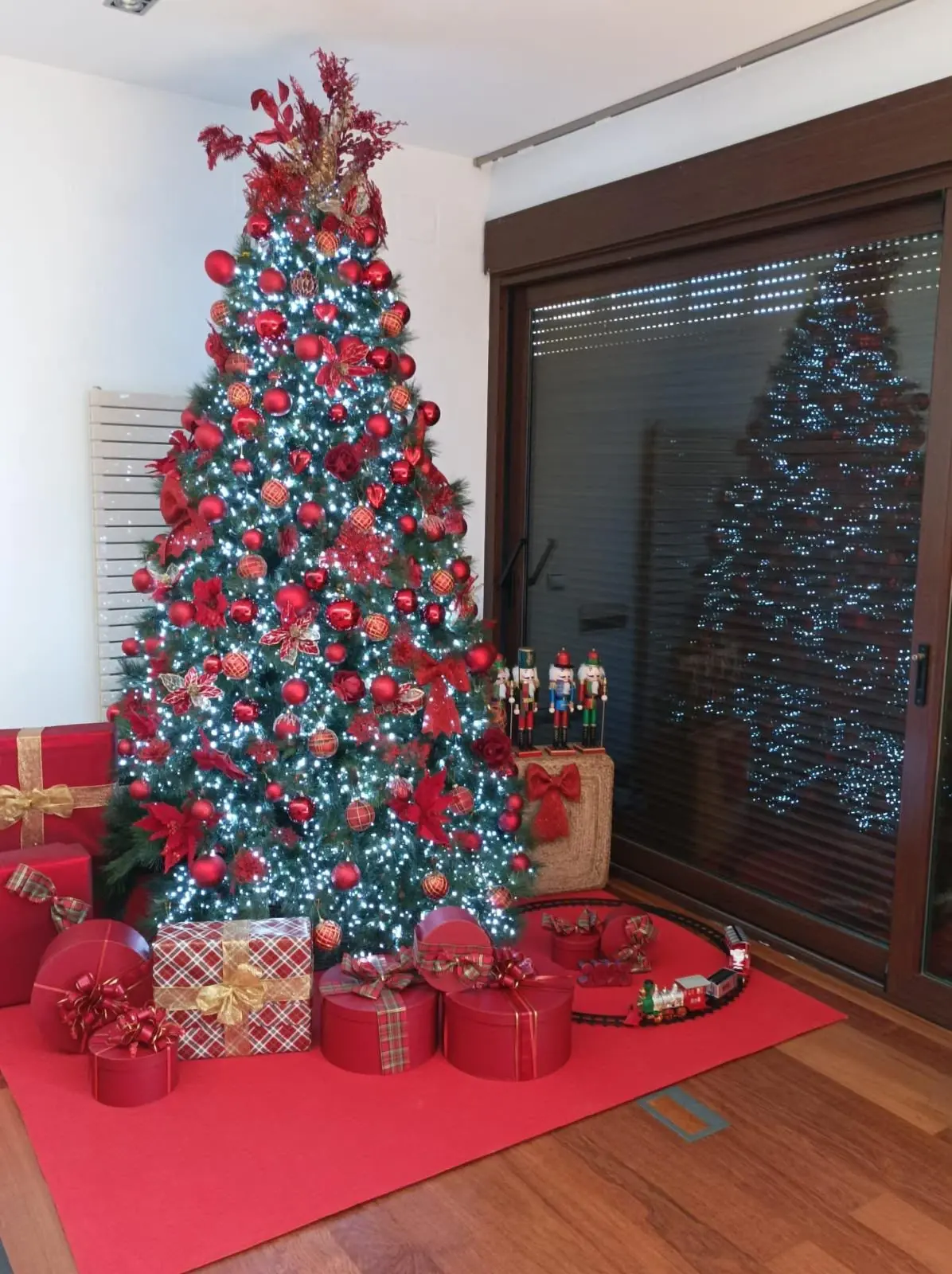 Árbol de Navidad en rojo con luces blancas y cascanueces decorativos, otro ejemplo de estilo