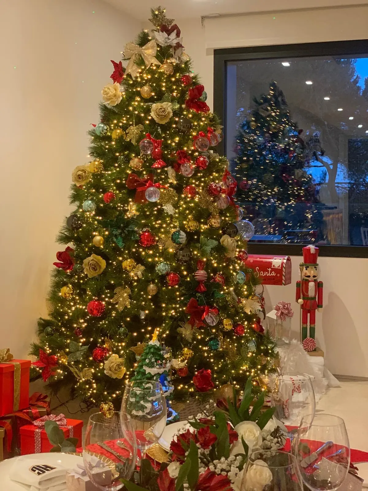 Árbol de Navidad en rojo y dorado terminado, junto a una mesa decorada